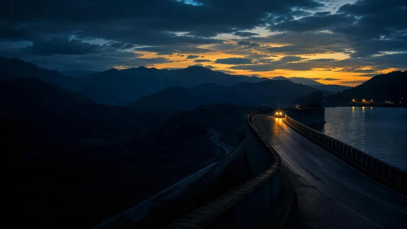 Estrada sobre a crista de uma barragem ao entardecer